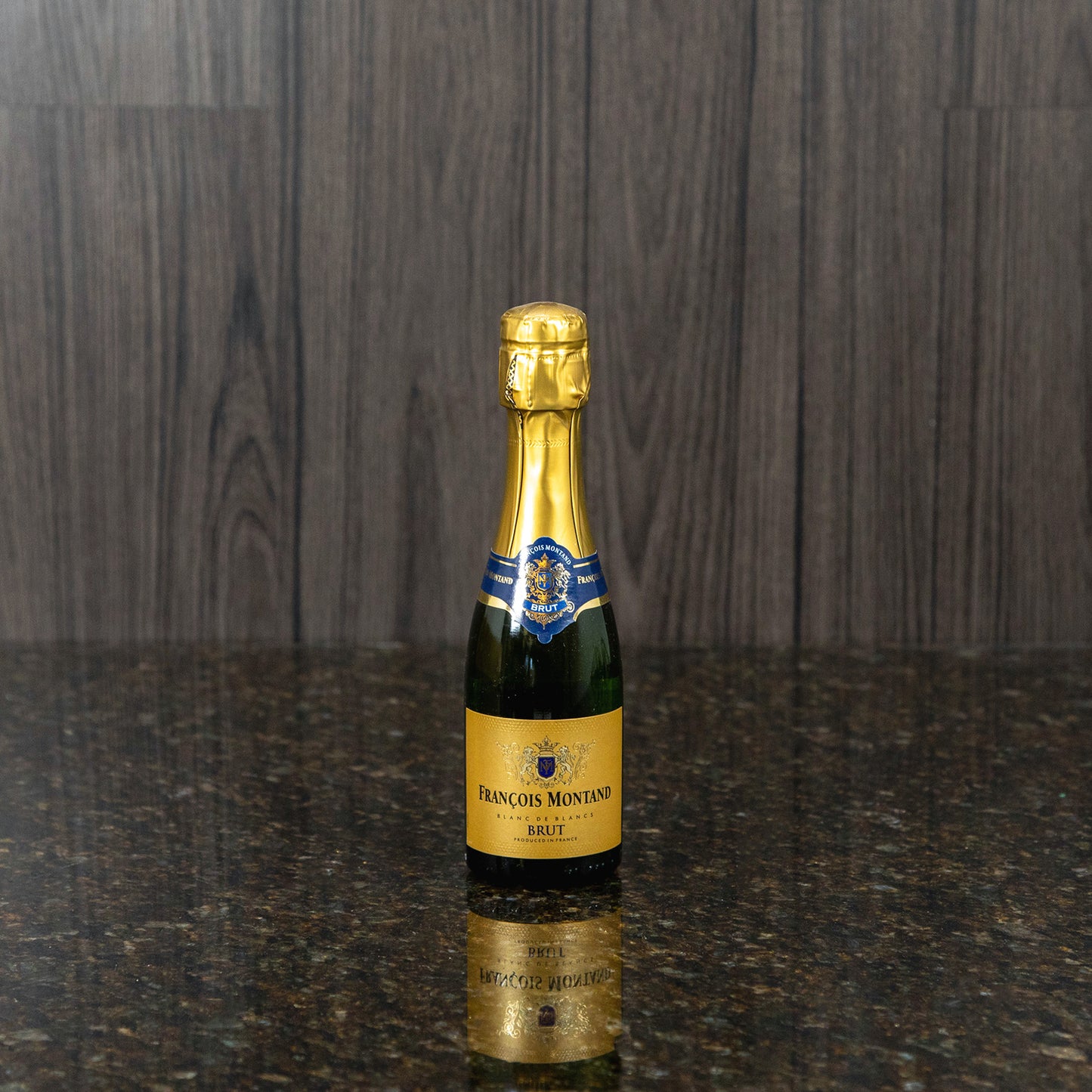 a small bottle of sparkling white wine with gold labels
