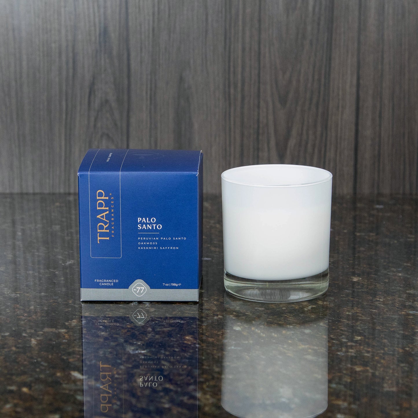 a white candle votive next to the "Palo Santo" box