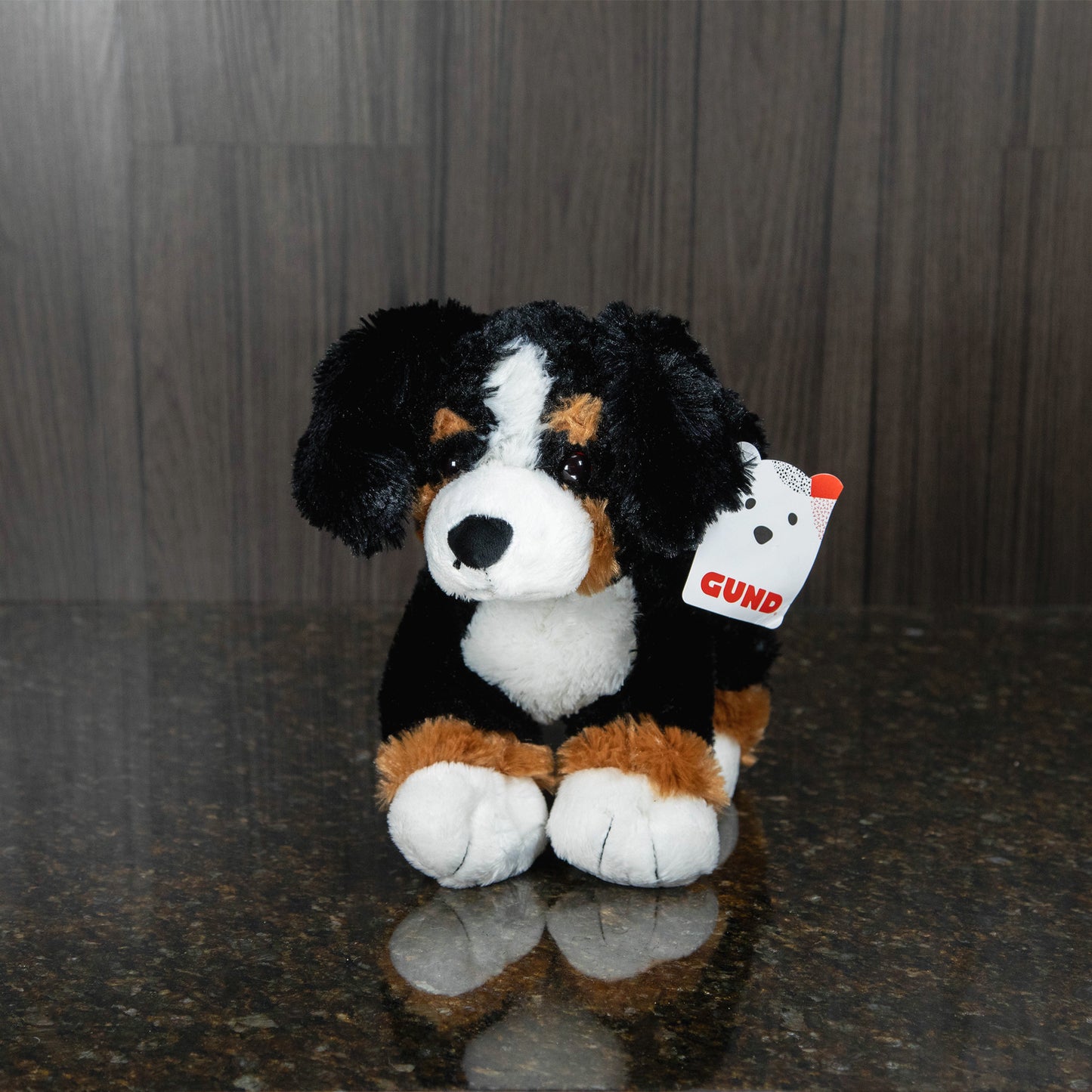 a plush bernese mountain dog lying on its stomach