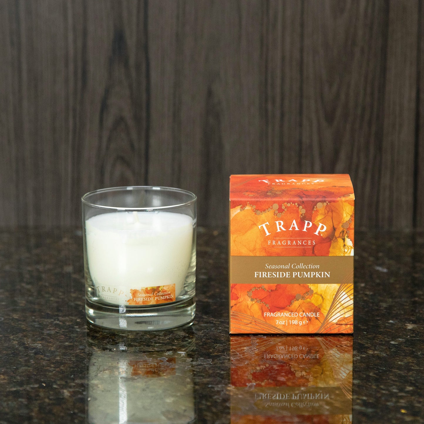 a fireside pumpkin scented candle next to the orange box it comes in