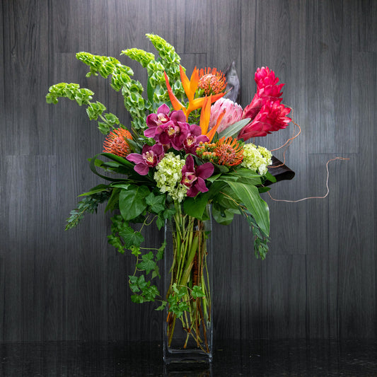 a large flower arrangement made with a variety of tropical flowers