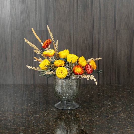 petite preserved yellow roses in a metallic footed glass vase with dried greenery and filler