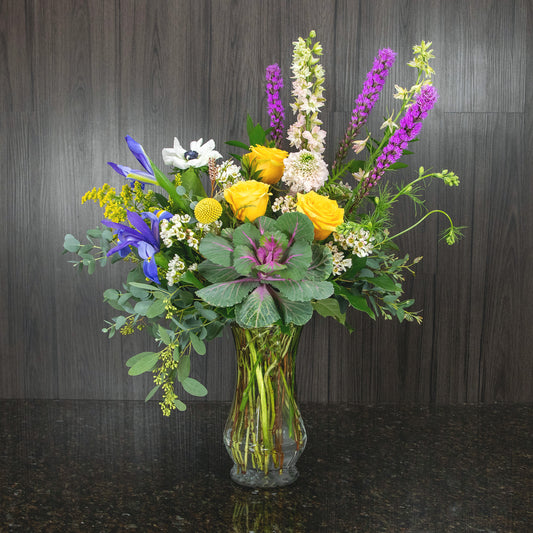 a colorful spring flower arrangement in a glass vase