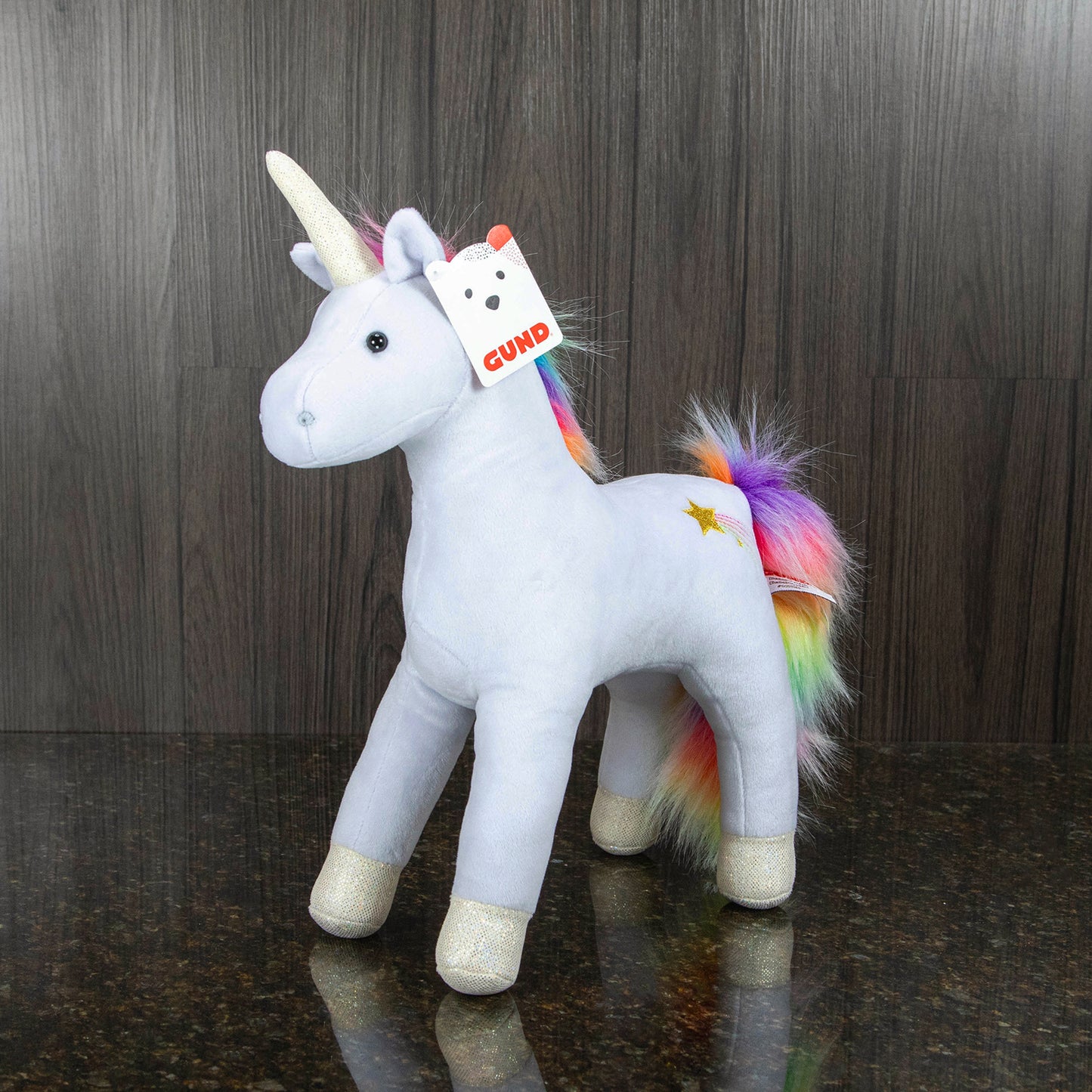a stuffed unicorn toy with a light blue body and a rainbow mane and tail