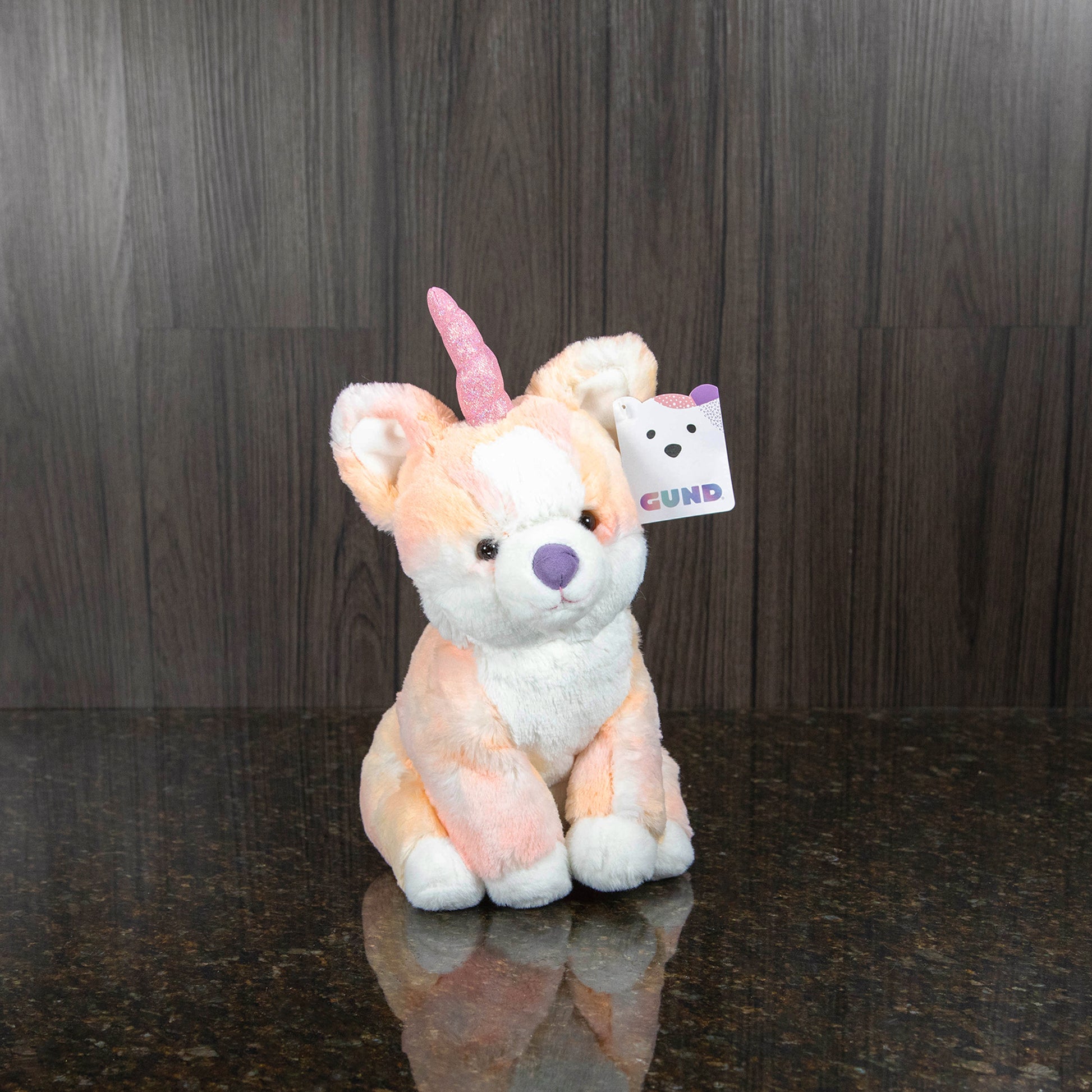 a plush corgi with a unicorn horn and pastel colorful body
