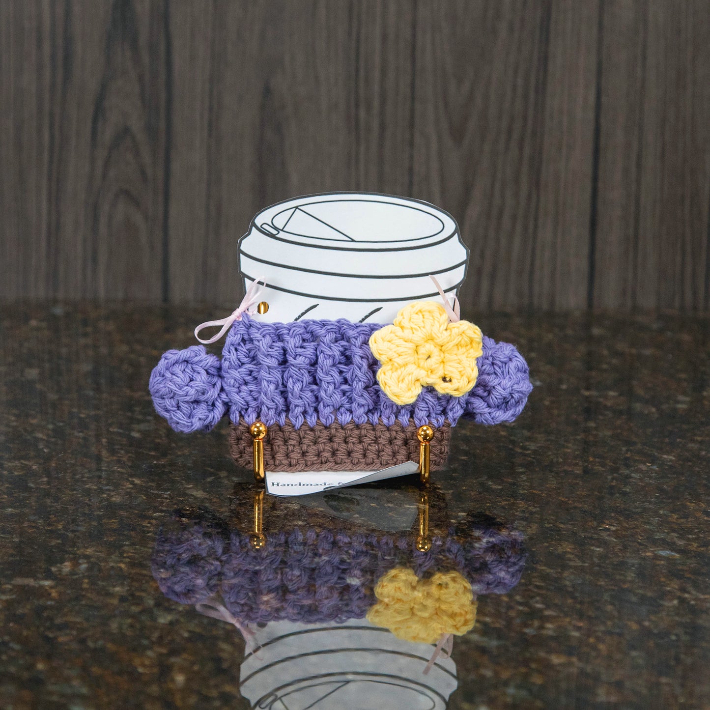 a crochet cup cozy that looks like a cactus - light purple with a yellow flower