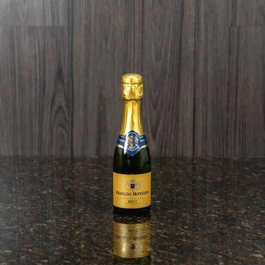 a small bottle of sparkling white wine with gold labels