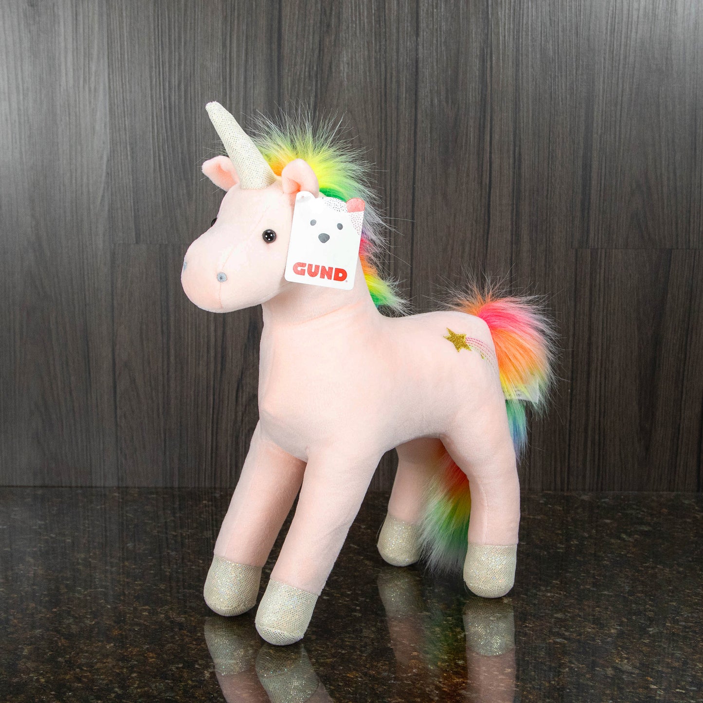 a unicorn stuffed animal with a light pink body and a rainbow mane and tail