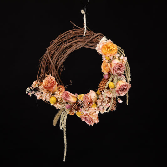 a dried floral wreath with a variety of peachy colored flowers