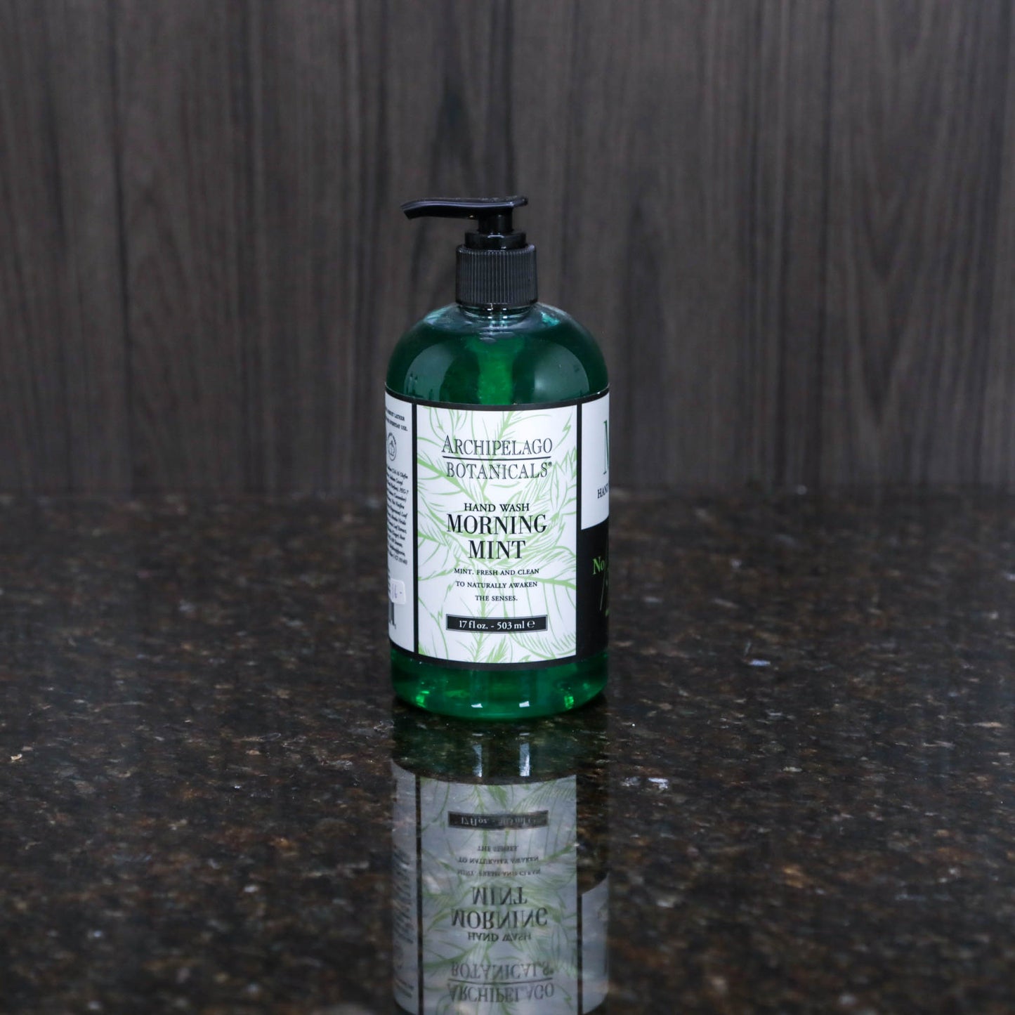 a soap pump with liquid soap in an opaque dark green color