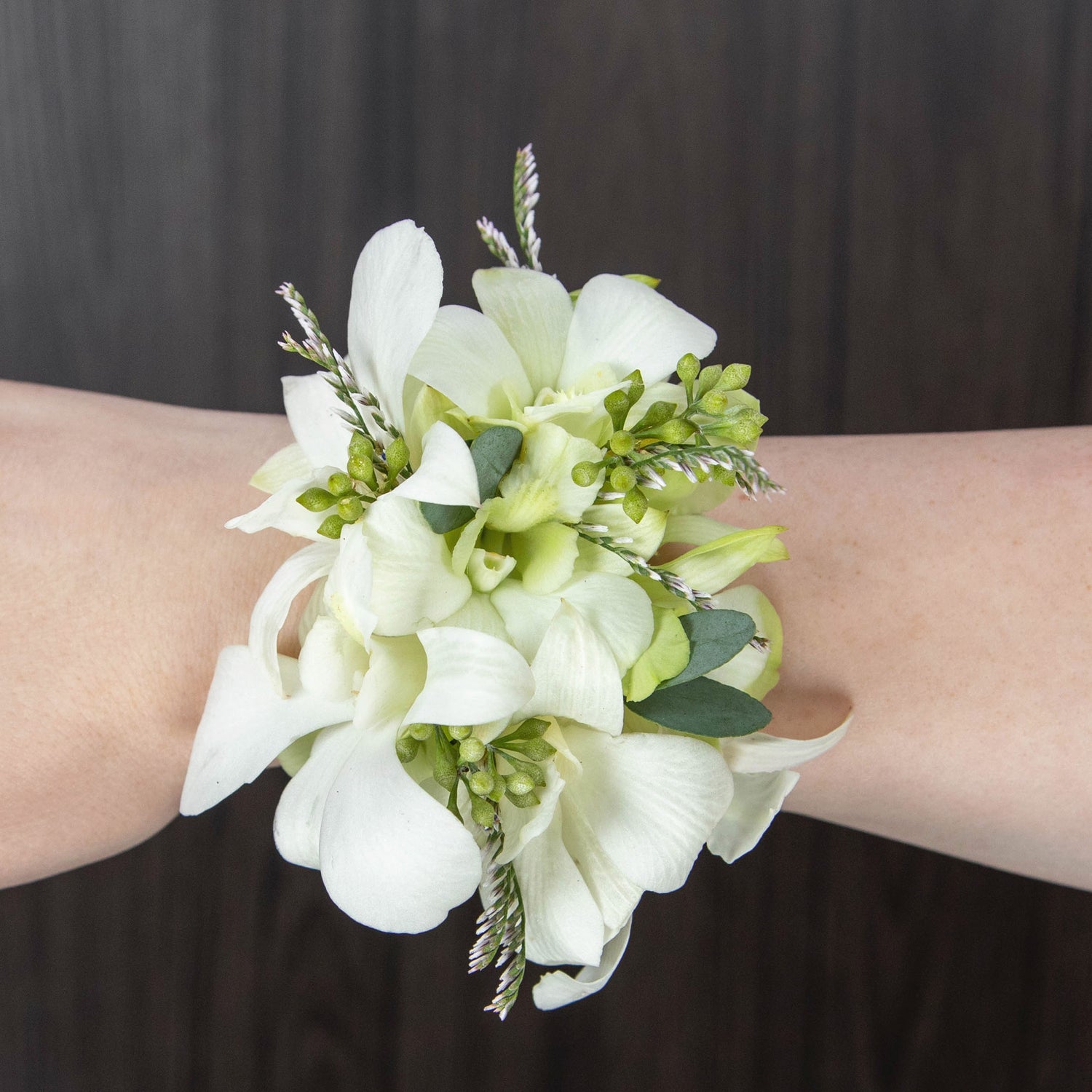 a wrist corsage with white dendrobium orchids