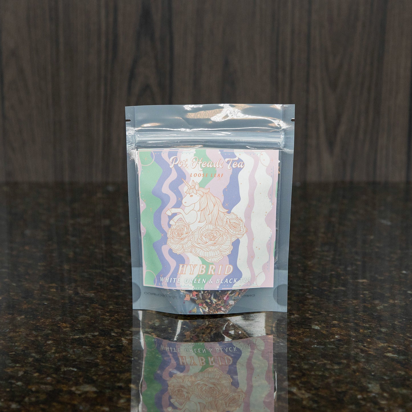 a packet of loose leaf tea with a pink, green, purple, and white label