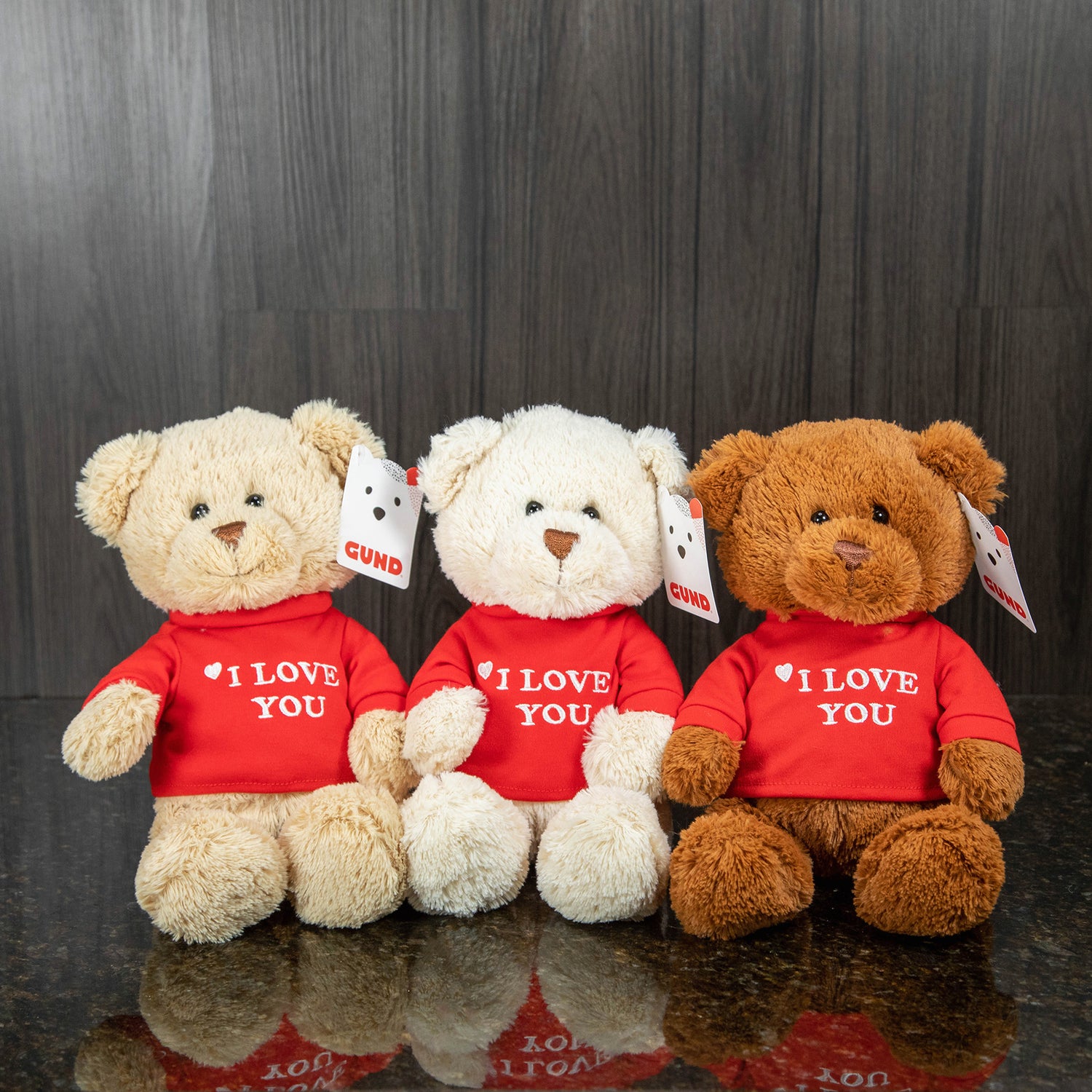three different teddy bears in varying shades of brown wearing a red shirt that reads "I love you"