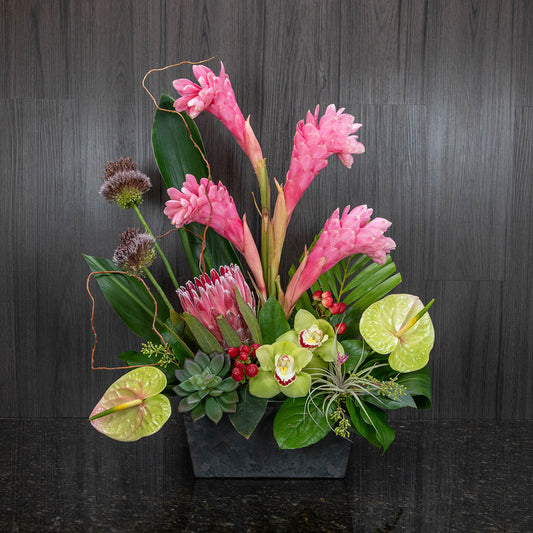 a tropical flower arrangement with a mix of flowers including tall stems of pink ginger