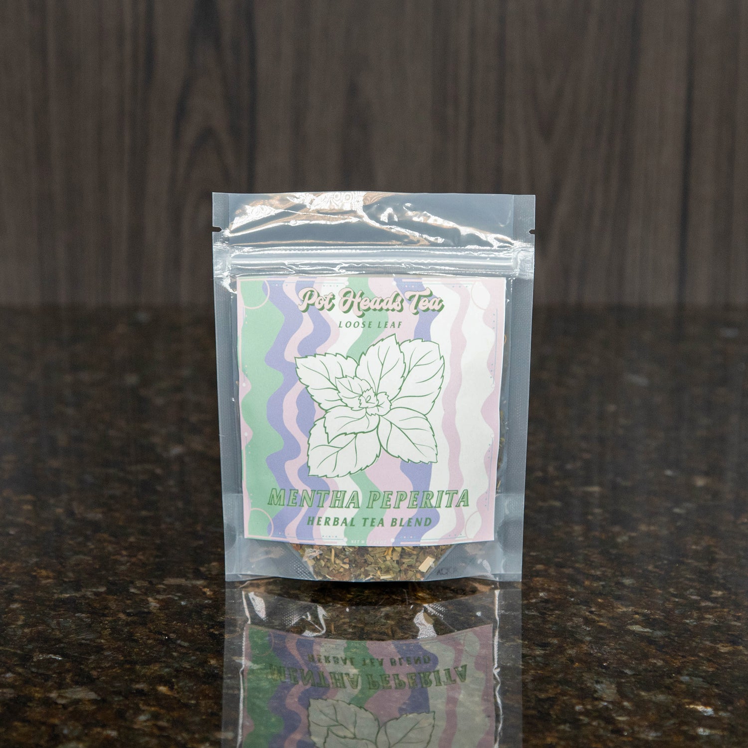 a packet of loose leaf tea with a pink, green, purple, and white label