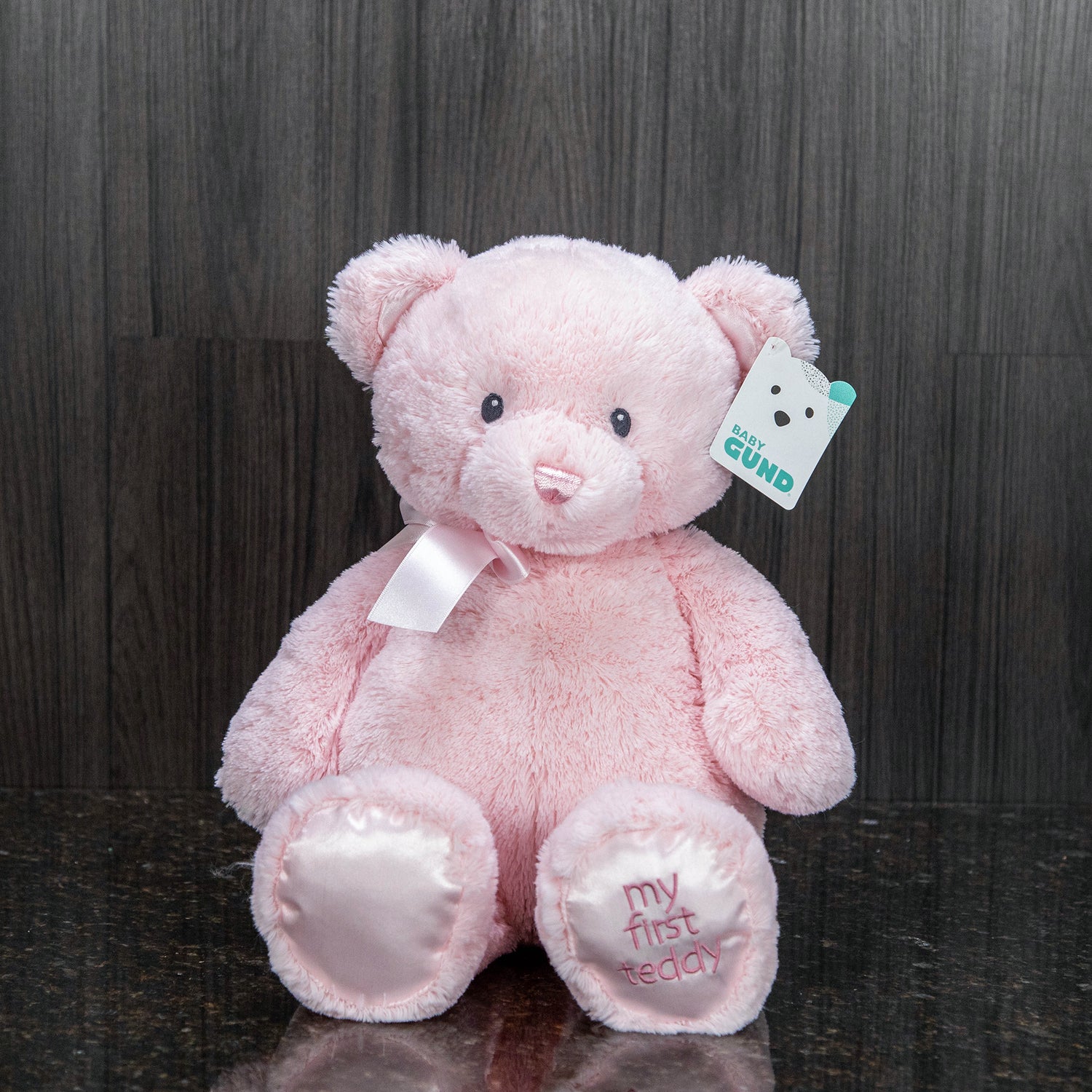 a blue teddy bear with "my first teddy" embroidered on its foot