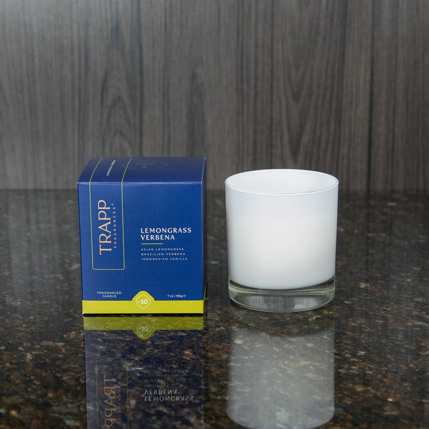 a white candle votive next to the "Lemongrass Verbena" box