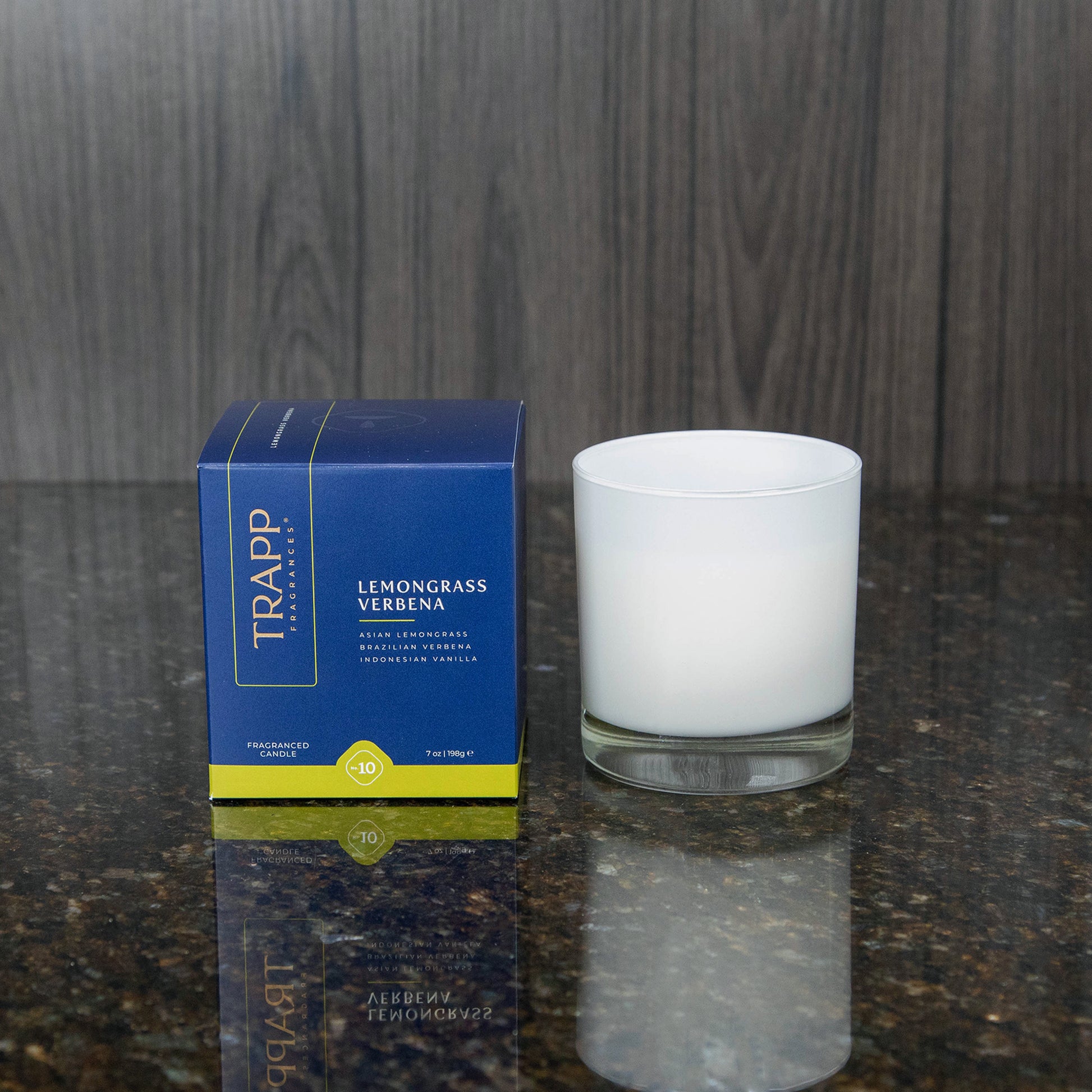 a white candle votive next to the "Lemongrass Verbena" box