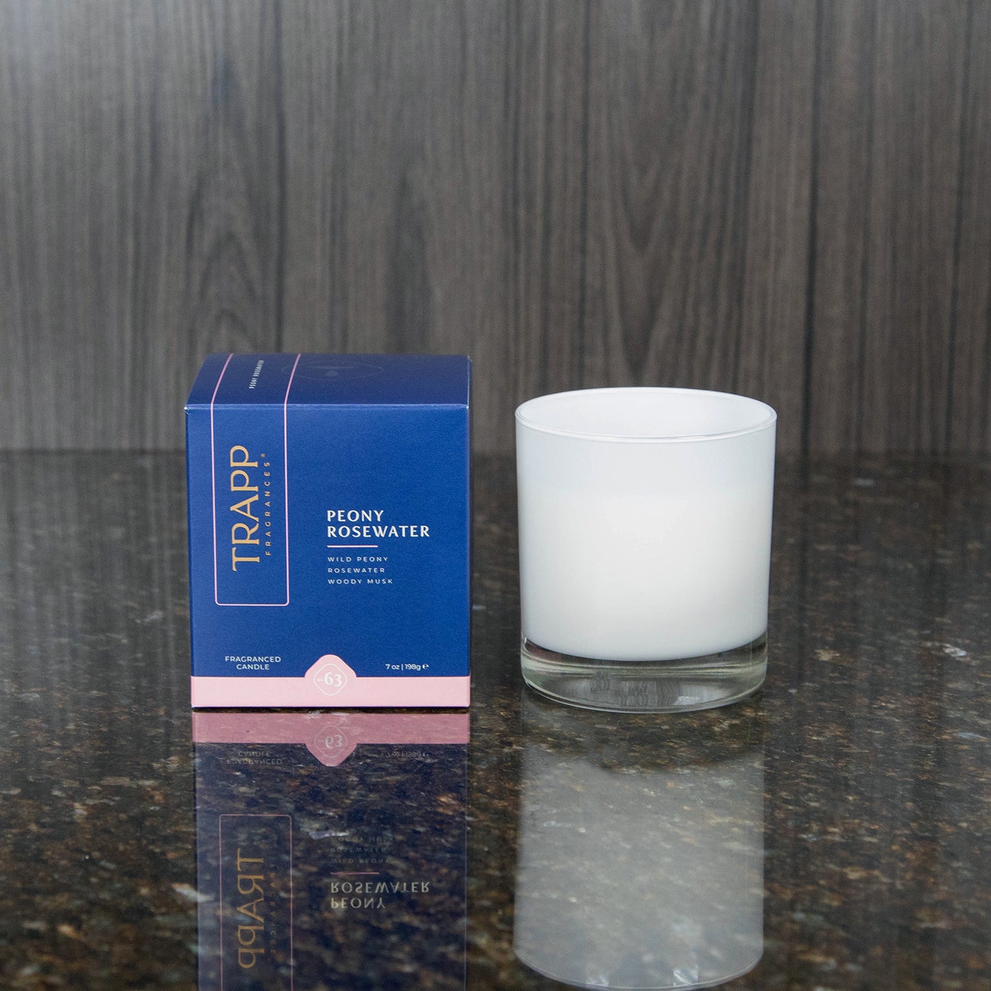 a white candle votive next to the "Peony Rosewater" box