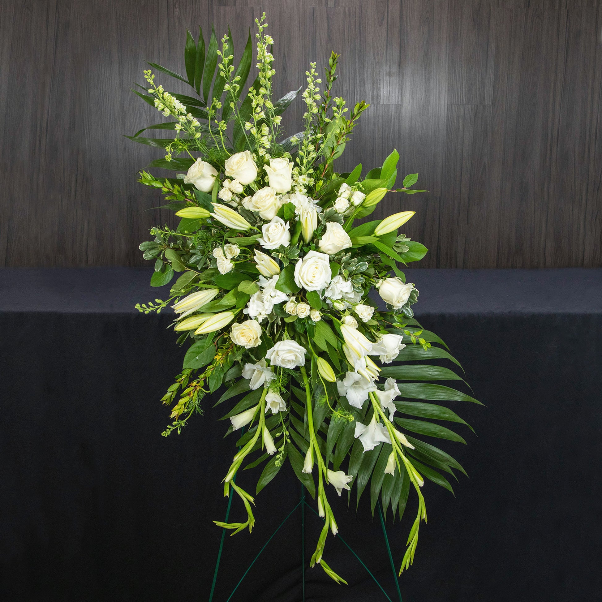 a easel funeral spray with all white flowers and greenery