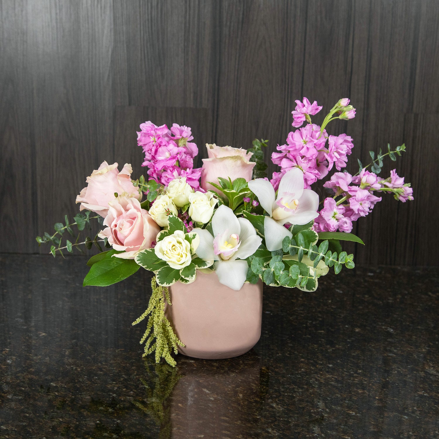 a flower arrangement with a mix of pink and white flowers in a pink ceramic vase