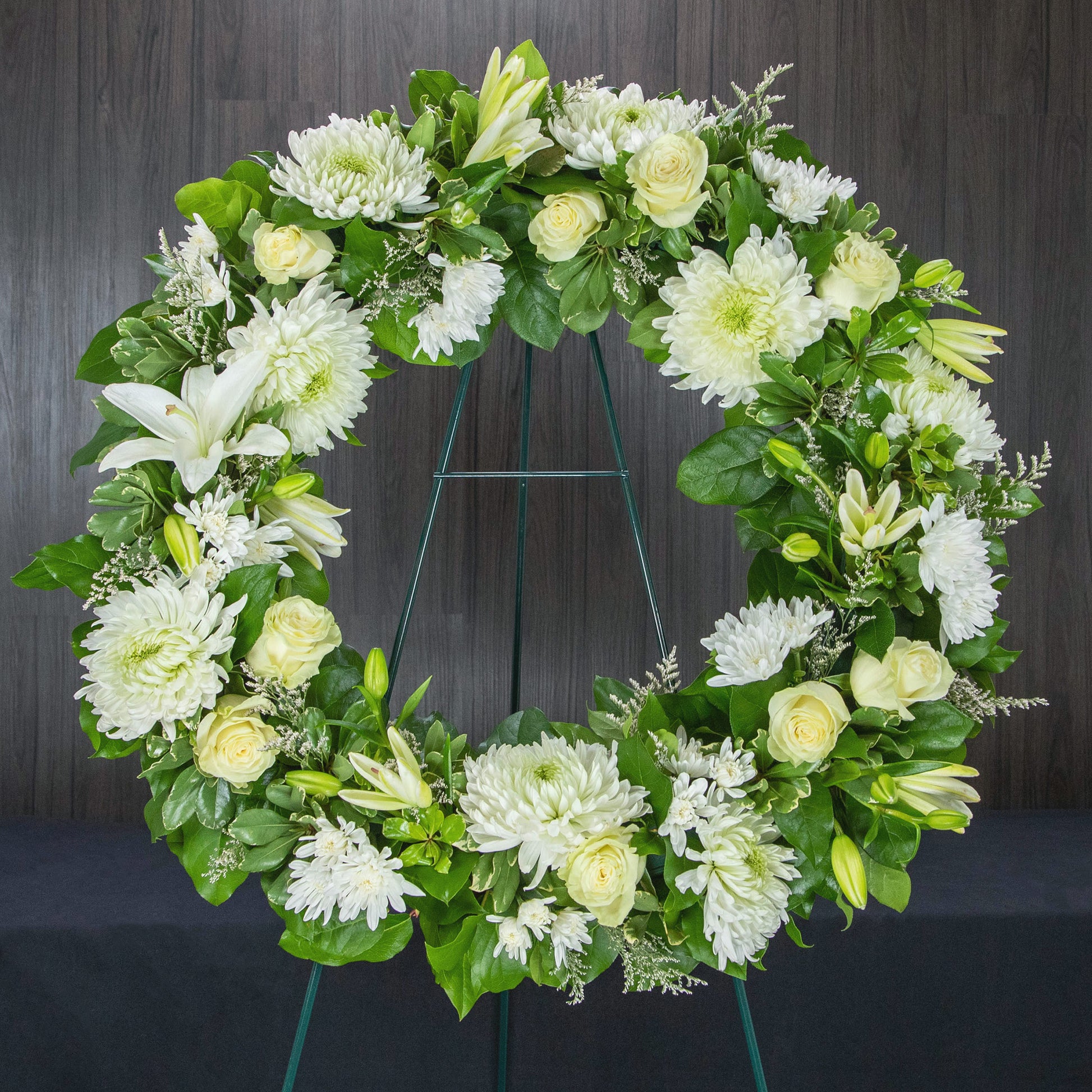 a large wreath made with white flowers and greenery