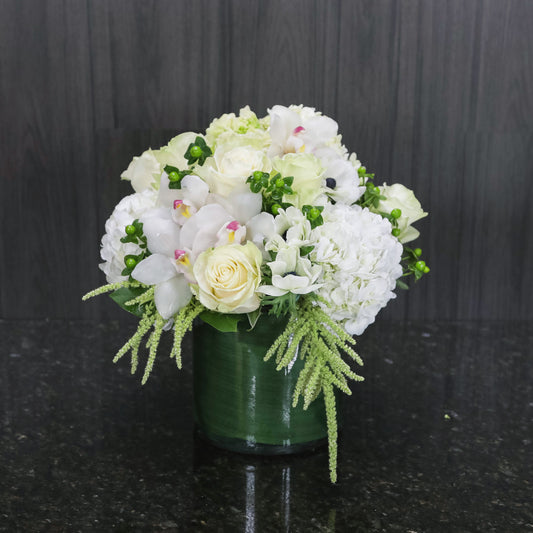 a compact flower arrangement with white and green flowers