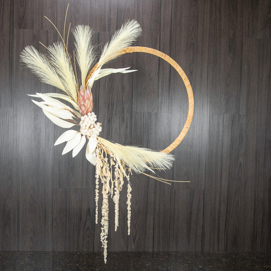 a hoop with dried florals and botanicals along the left side and draping down